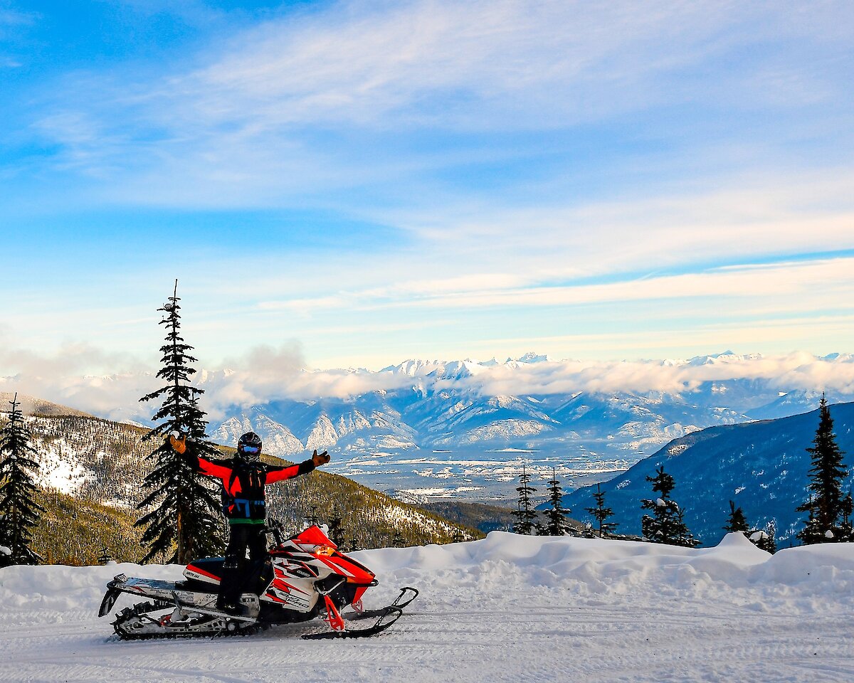 Snowmobile enjoying the views on a stop during Paradise Basin snowmobile tour