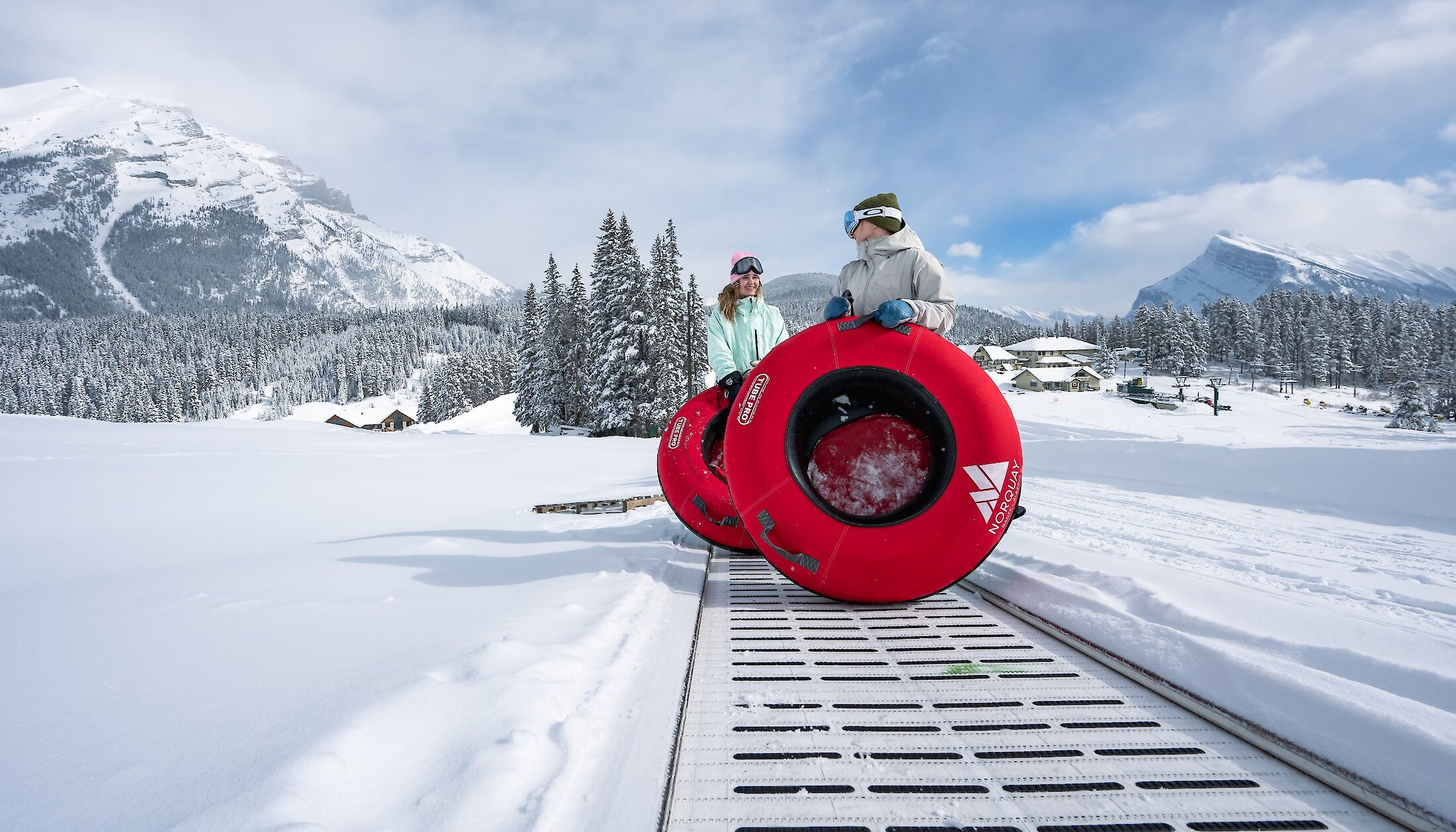 Riding the magic carpet with a  snow tube after sliding down the lanes at Mount Norquay