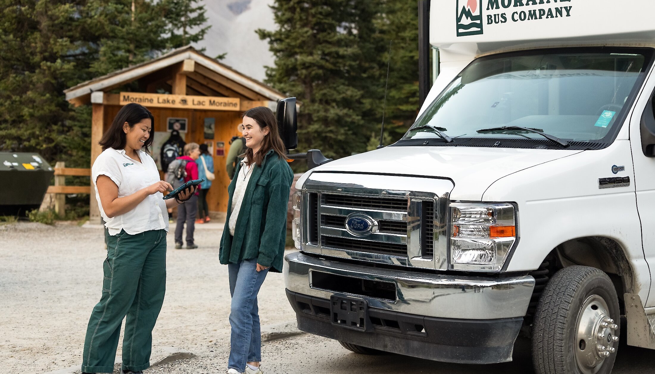 A guest chatting to the driver about Moraine Lake Bus Company