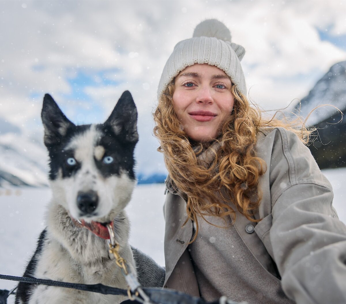 A smiling lady with a dogsled husky on spray lakes