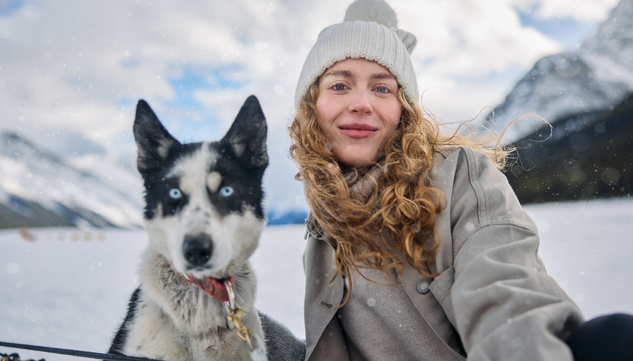 A lady and dog on the dogsledding trail in Kananaskis