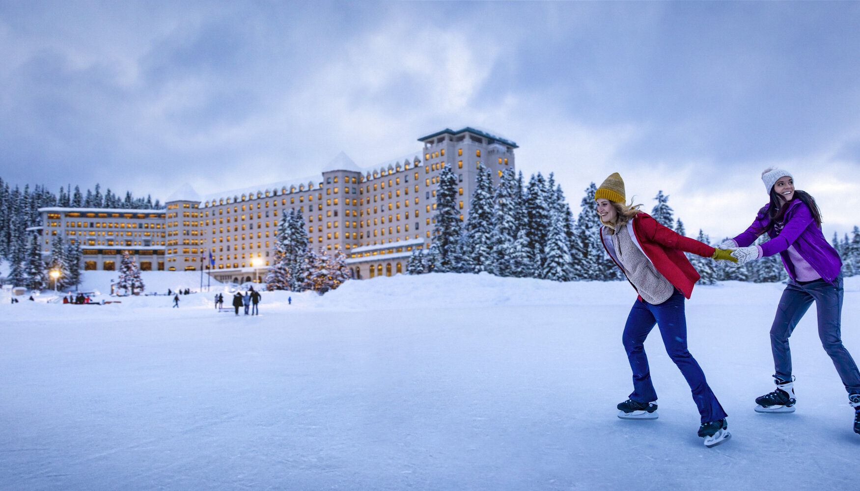 Two friends ice skating on frozen Lake Louise