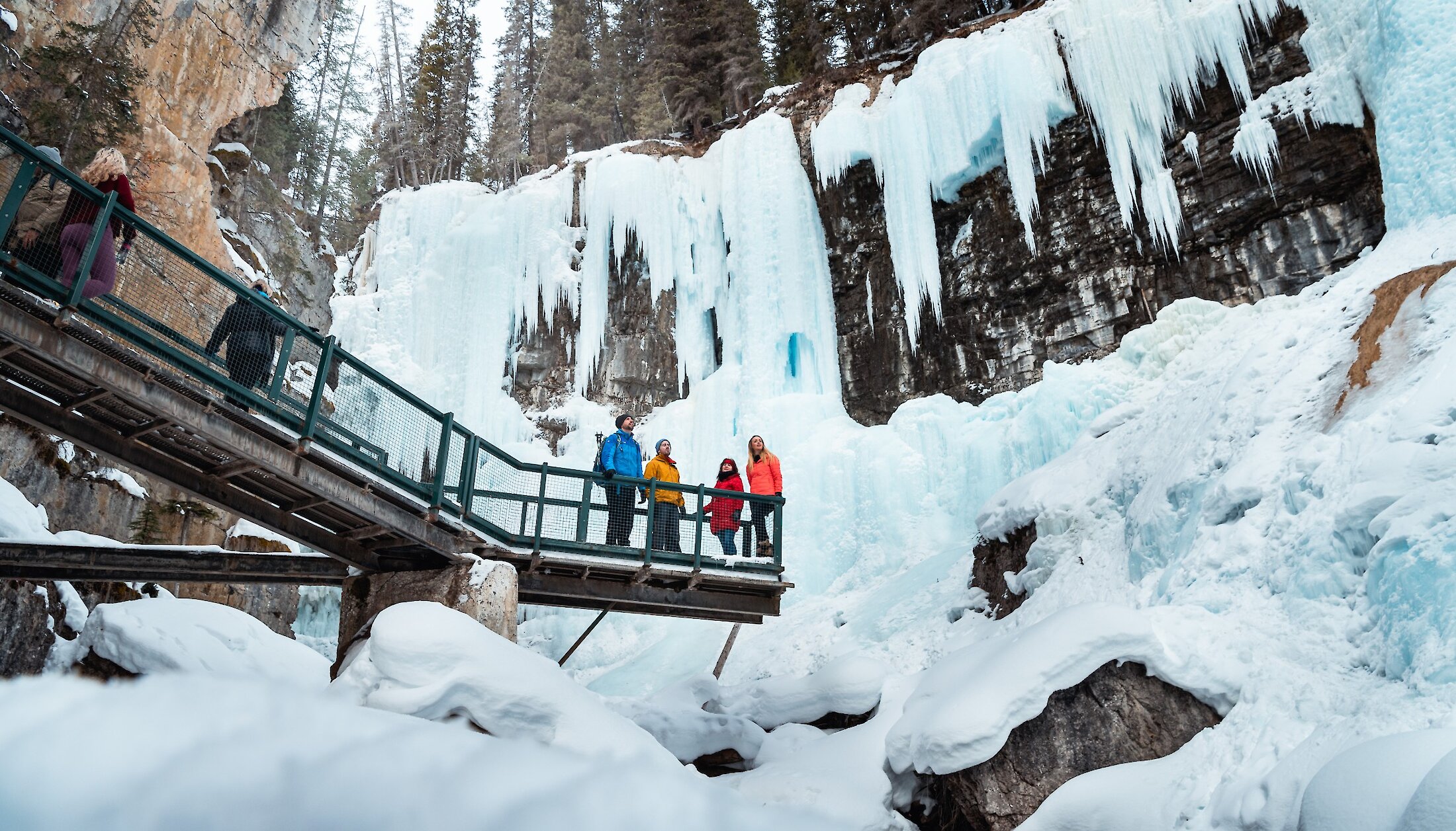 A group of friends looking at the ice fall of upper Johnston Canyon