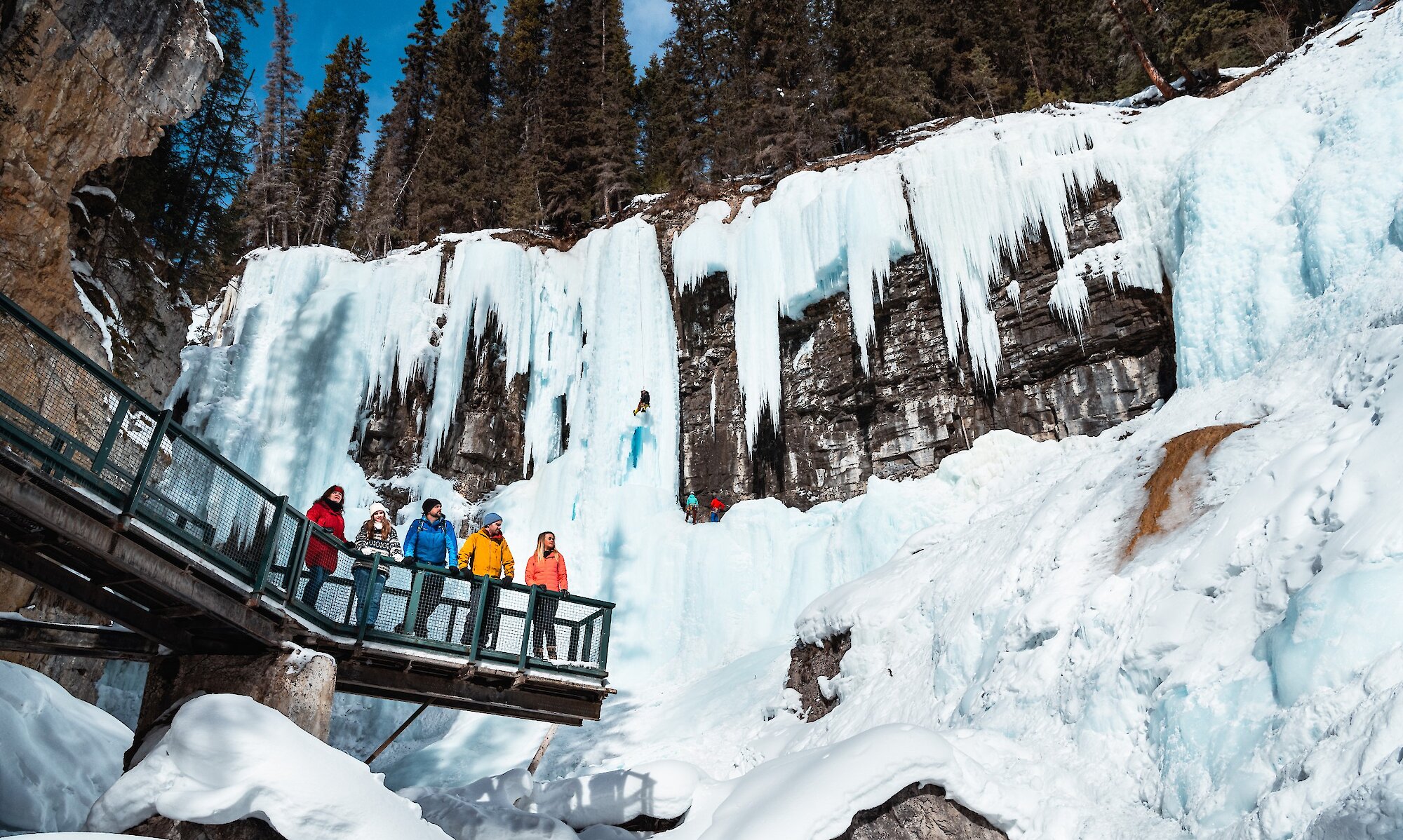 A group admiring the frozen upper falls icefalls at Johnston Canyon