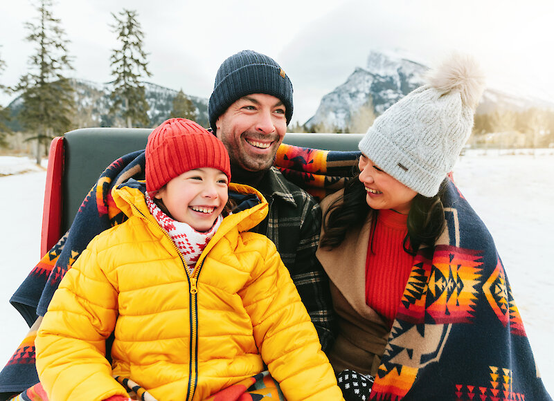 A family enjoying a private sleigh ride through the Banff meadows