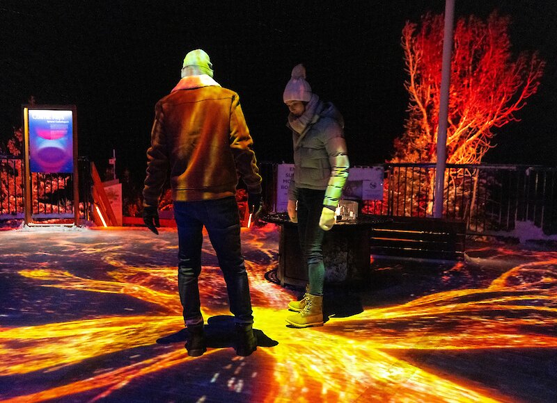 A couple enjoying nightrise at the Banff Gondola