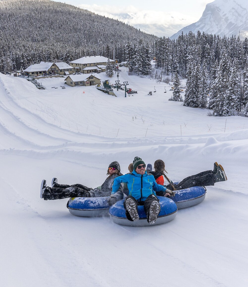 A group enjoying sliding down the lanes at the Mount Norquay Tube Park